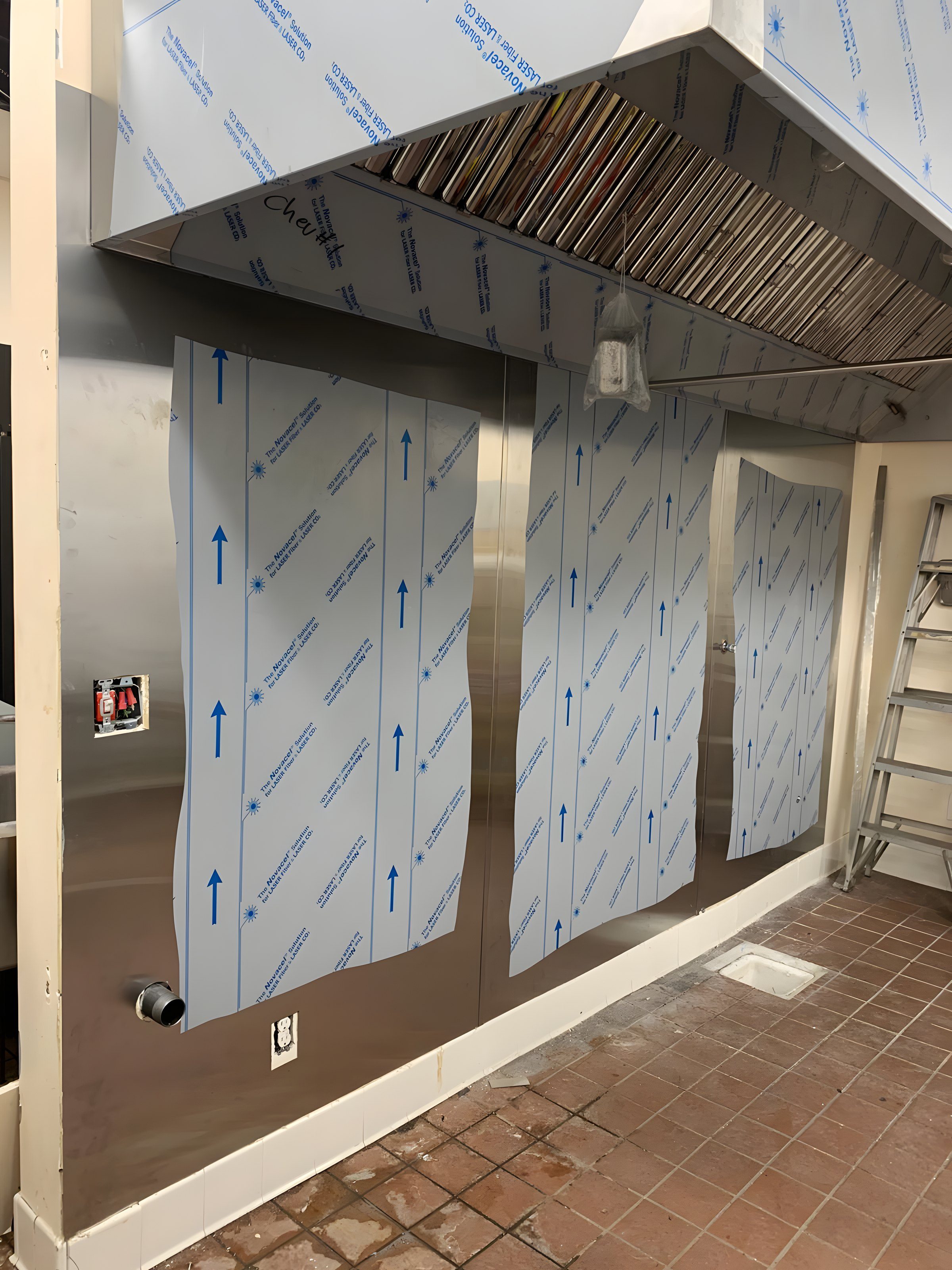 A new stainless kitchen hood installed, protective film still on