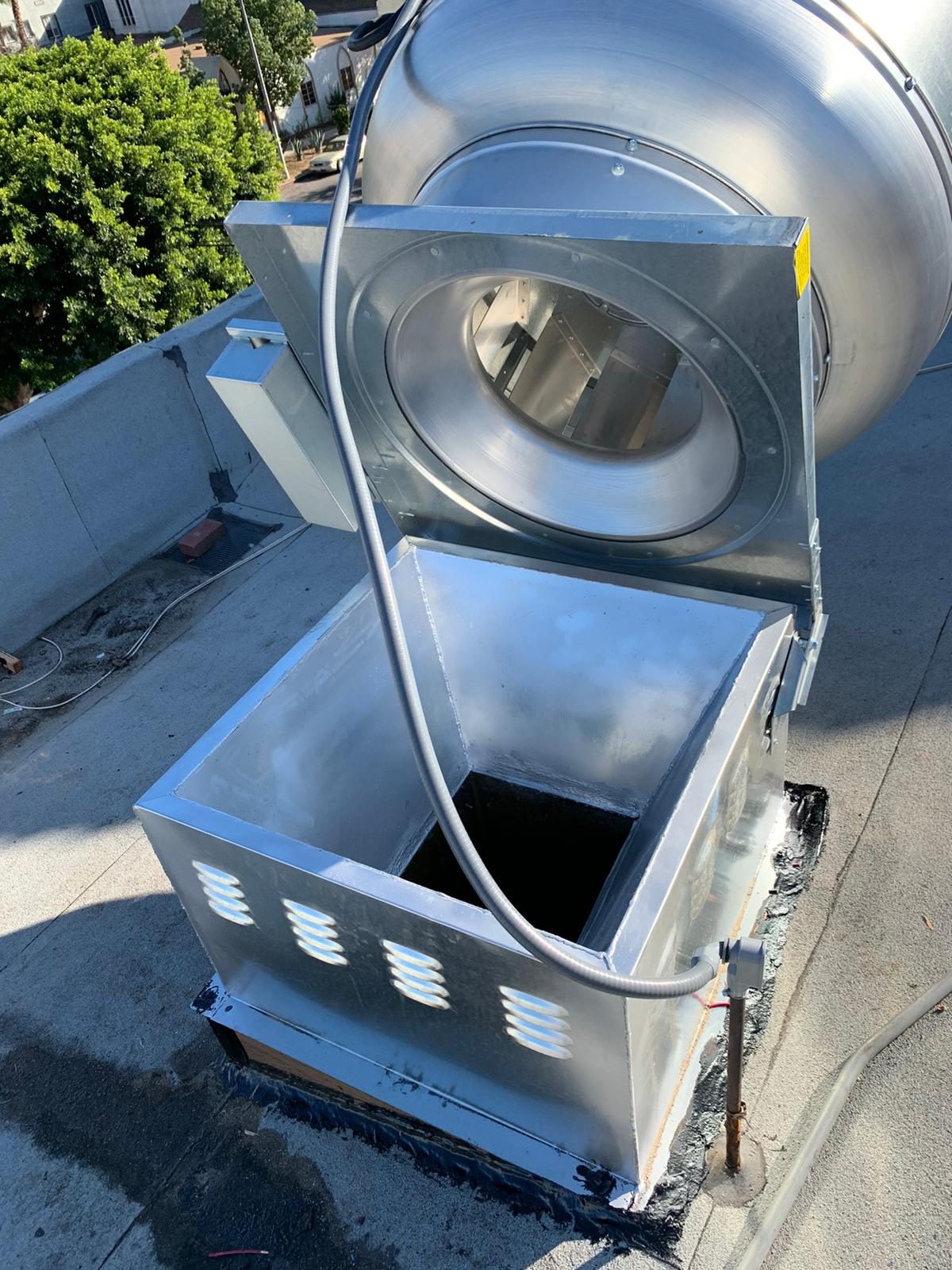 A rooftop exhaust fan opened up for service